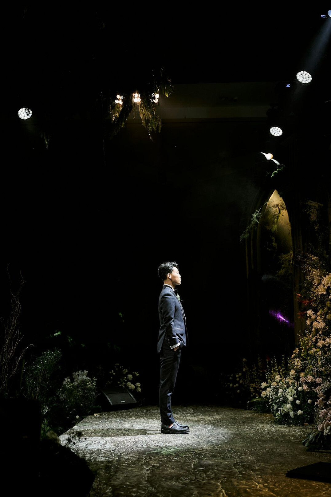 Man in black suit standing on a stage