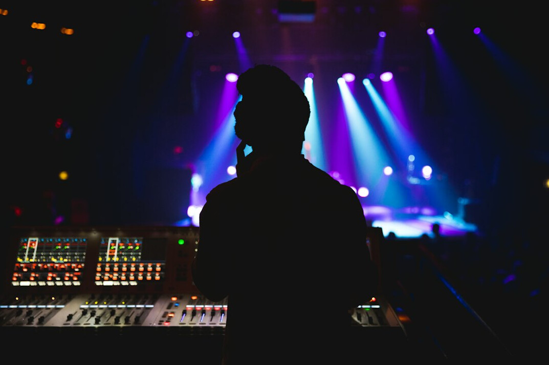 Silhouette of a sound engineer using an audio mixer